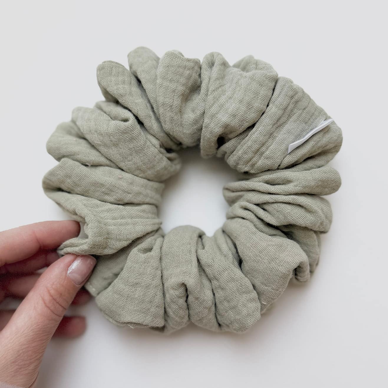 Noelle Classic Scrunchie z miękkiego muślinu 100% bawełny w zielonkawo-szałwiowym kolorze, delikatnie otulająca włosy, zapewniająca komfort noszenia i naturalny, lekki efekt fryzury bez ucisku i odgnieceń