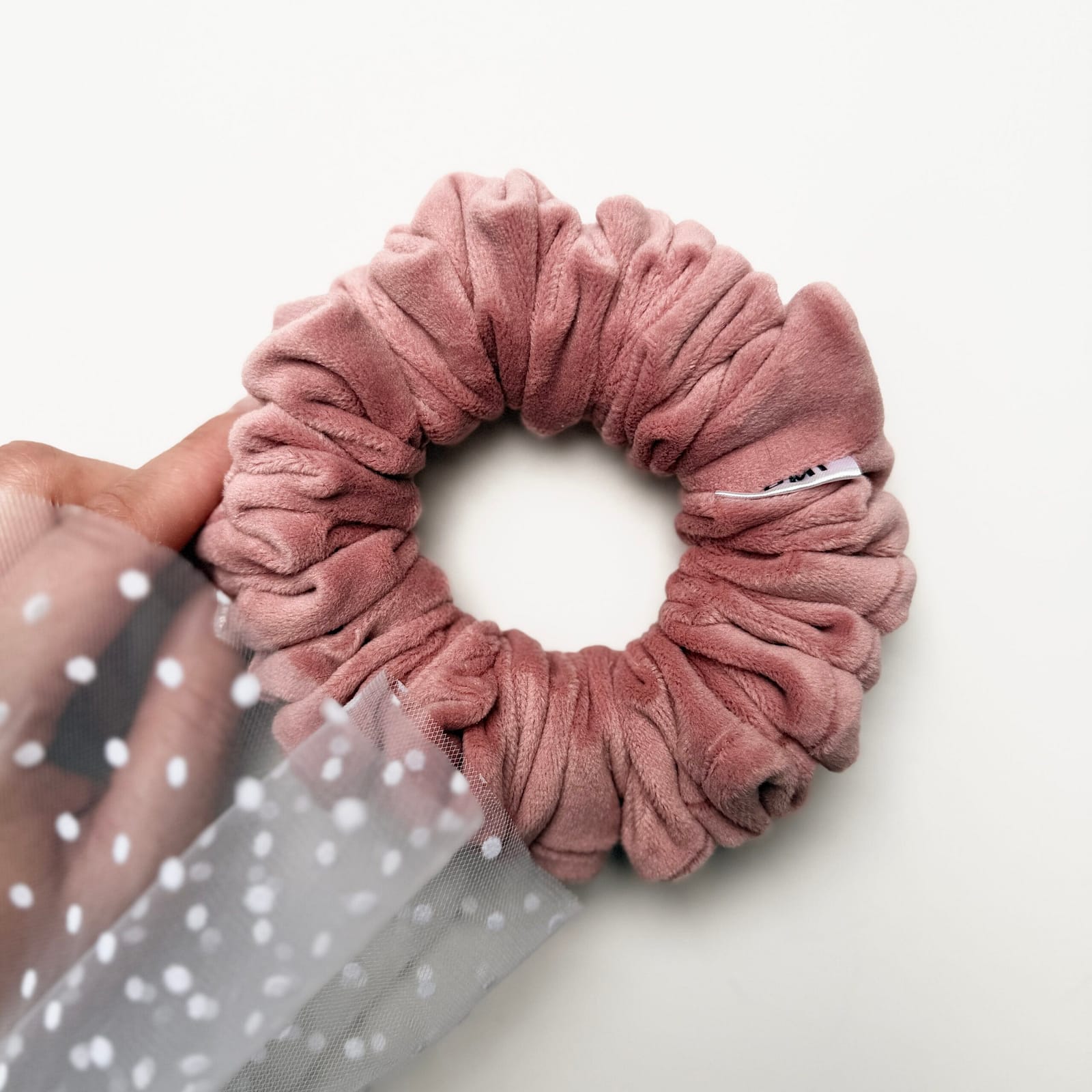 Rosalia Skinny Scrunchie z miękkiego weluru w kolorze różowym, delikatnie otulająca włosy, zapewniająca komfort noszenia i naturalny, lekki efekt fryzury bez ucisku i odgnieceń