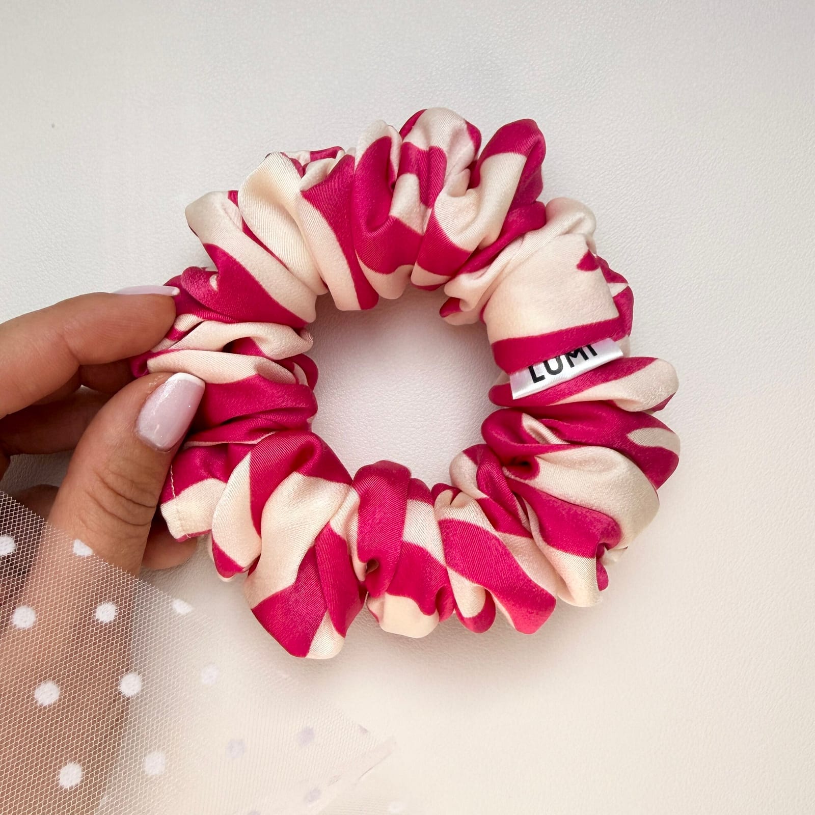 Ręcznie szyta satynowa gumka do włosów Estela Skinny Scrunchie w różowo-kremowy wzór, prezentowana na białym tle.