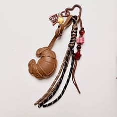 Brelok Croissant&Toast to wyrazisty brelok do kluczy z detalami inspirowanymi stylem sportowym. Mocne formy, kontrastowe kolory i elementy, które naprawdę widać w torebce.